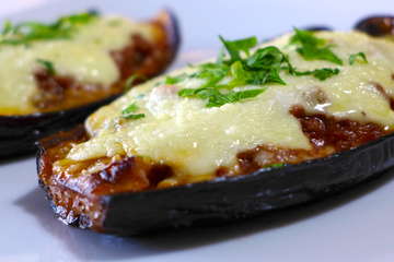 greek stuffed eggplant in a white casserole dish topped with creamy Béchamel sauce and mashed potatoes